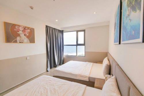 a bedroom with two beds and a window at Sóng Homestay-The Sóng Apartment Vũng Tàu Nghỉ Dưỡng Biển Cao Cấp 5 Sao- The Song Vung Tau Condotel 5 Star Beach View Apartment in Vung Tau