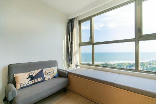 a couch in a room with a large window at Sóng Homestay-The Sóng Apartment Vũng Tàu Nghỉ Dưỡng Biển Cao Cấp 5 Sao- The Song Vung Tau Condotel 5 Star Beach View Apartment in Vung Tau