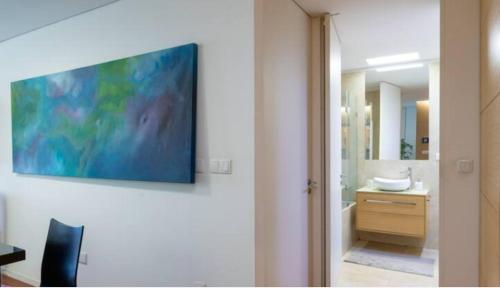 Un baño con un televisor en la pared y un lavabo. en Porto H Dragão, en Oporto