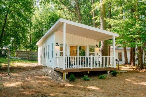 a tiny house in the woods with a porch at Beach l Hot Tub l Arbutus Lake l 15 min to DT TC in Traverse City