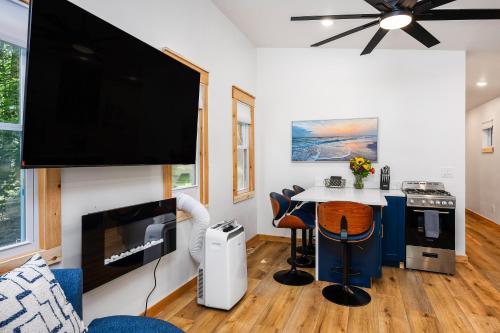 a living room with a tv and a table with chairs at Beach l Hot Tub l Arbutus Lake l 15 min to DT TC in Traverse City