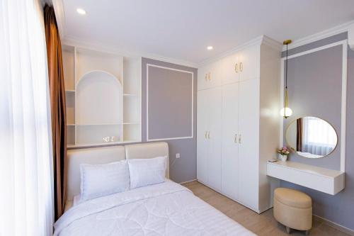 a small bedroom with a white bed and a mirror at Sóng Homestay-The Sóng Apartment Vũng Tàu Nghỉ Dưỡng Biển Cao Cấp 5 Sao- The Song Vung Tau Condotel 5 Star Beach View Apartment in Vung Tau