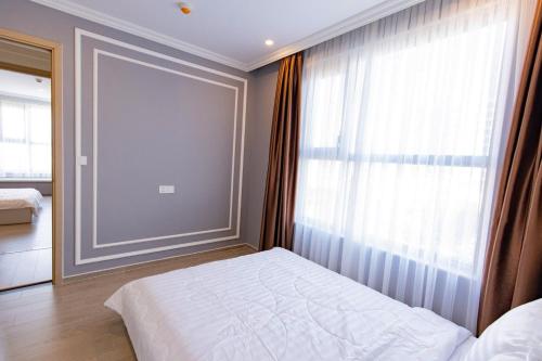 a bedroom with a bed and a large window at Sóng Homestay-The Sóng Apartment Vũng Tàu Nghỉ Dưỡng Biển Cao Cấp 5 Sao- The Song Vung Tau Condotel 5 Star Beach View Apartment in Vung Tau