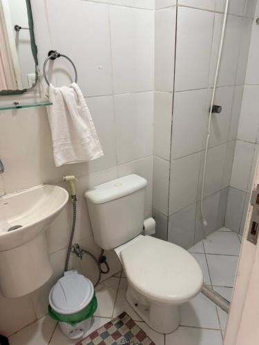 a bathroom with a toilet and a sink and a shower at Apartamento aconchegante in Lauro de Freitas
