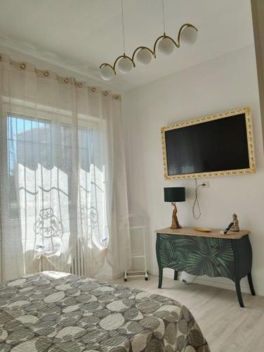 una camera da letto con un letto e una TV a parete di La Casa di Gabri Humanitas ForumAssago Milano centro a Rozzano