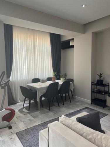 un soggiorno con tavolo, sedie e divano di Квартира a Baku