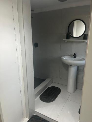 a small bathroom with a sink and a mirror at Peaamb GuestHouse - Springs Golf Club in Springs
