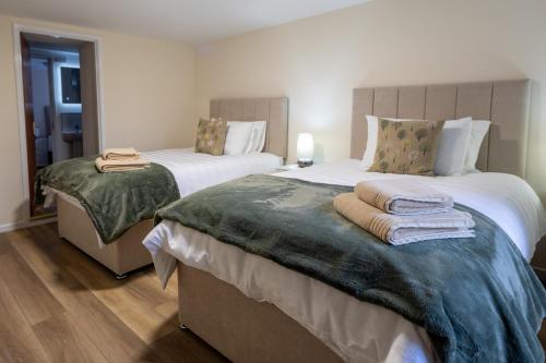 a bedroom with two beds with towels on them at Killard Farm in Bellaghy