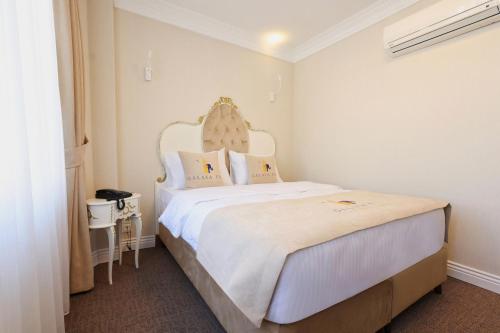 a bedroom with a large white bed with a headboard at Galata Fil Hotel in Istanbul