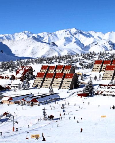 a group of people skiing down a snow covered mountain at Condominio Atuel con Cocina Wifi Cochera Desayuno in San Rafael