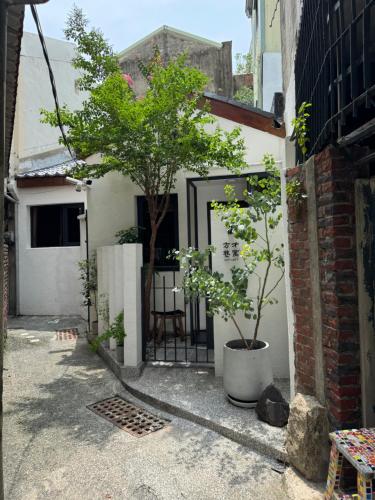 een deur naar een gebouw met twee bomen erin bij Just meet in Tainan