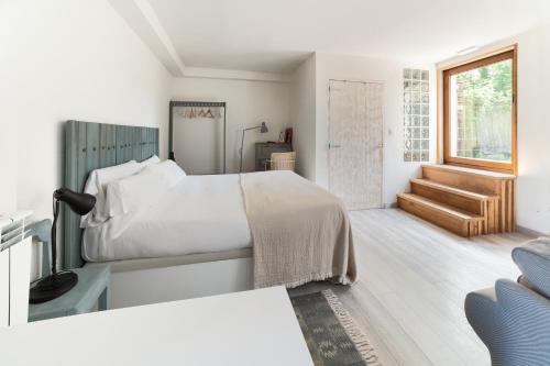 a white bedroom with a bed and a window at Casa Rural Ulle Gorri in Unzá