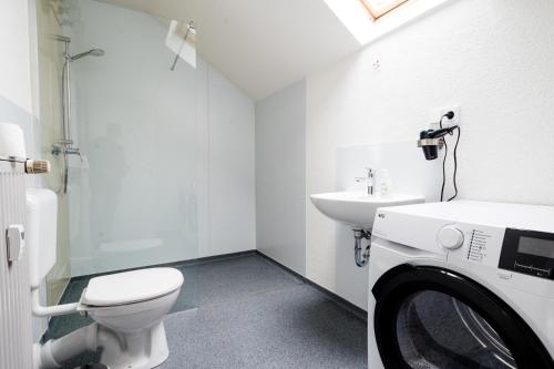ein Badezimmer mit Toilette, Waschbecken und Waschmaschine in der Unterkunft janu-homes - 3 Zimmer Apartment - 7 Betten, Lahnblick vom Römer in Runkel