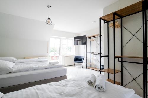 ein Schlafzimmer mit zwei Betten und einem Stuhl in der Unterkunft janu-homes - 3 Zimmer Apartment - 7 Betten, Lahnblick vom Römer in Runkel