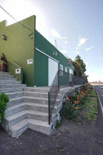 a green building with stairs next to a street at Casa Los Bernales in Las Indias