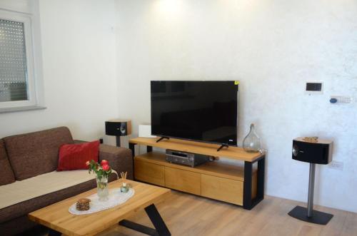 a living room with a couch and a flat screen tv at Villa Marbella in Ledine
