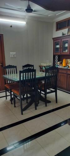 a dining room with a table and four chairs at Luxury bungalow in Patiāla