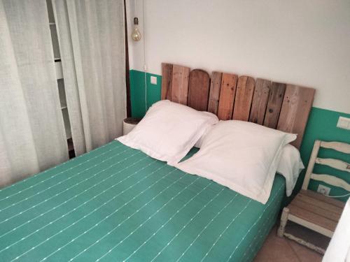 a bedroom with a green bed with white pillows at La Maison De Stephanie in Porto-Vecchio