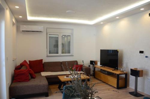 a living room with a couch and a tv at Villa Marbella in Ledine