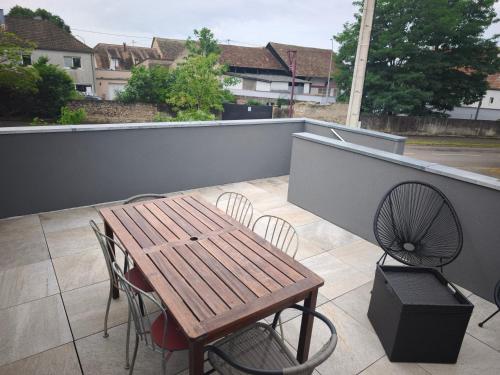 a wooden table and chairs sitting on a balcony at Près Colmar 6 bis in Wolfgantzen