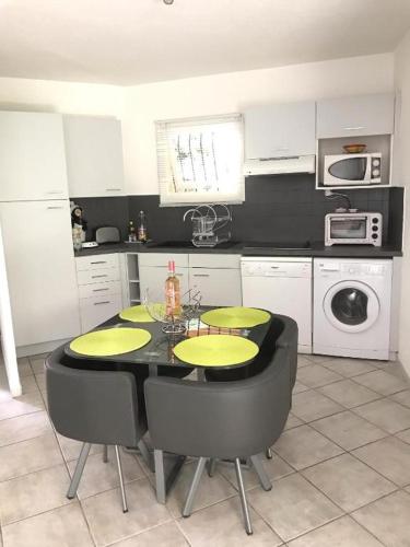 a kitchen with a table and chairs in a kitchen at Appartement Spacieux T2, Confortable Malibu Village, Canet-en-Roussillon in Canet-en-Roussillon