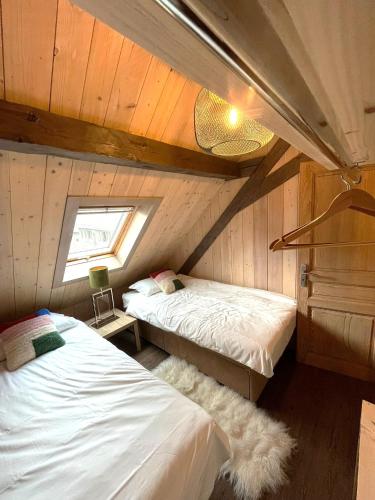 a bedroom with two beds and a window at Le Château - Appartement Génépi in Morzine