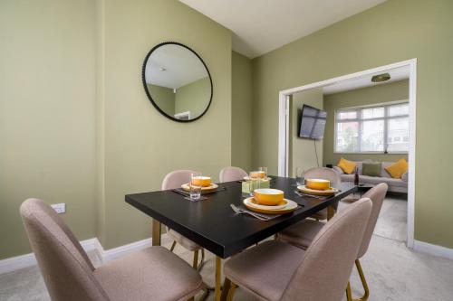 a dining room with a table with chairs and a mirror at Cooper stay - perfect for contractors in Grimsby