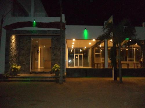 a building with green lights in front of it at night at Saara Beach Hotel in Marawila