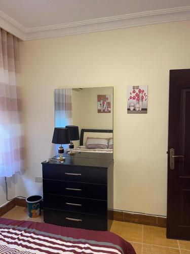 a bedroom with a bed and a large mirror at Furnished one bedroom apartment in Amman