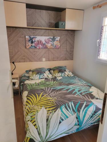 Un dormitorio con una cama con un edredón colorido. en Domaine de Kermario, en Carnac
