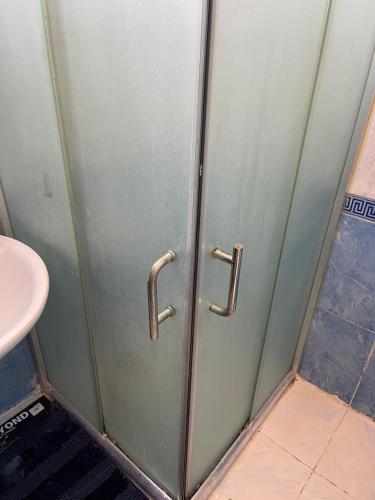 a metal door in a bathroom with a sink at Furnished one bedroom apartment in Amman