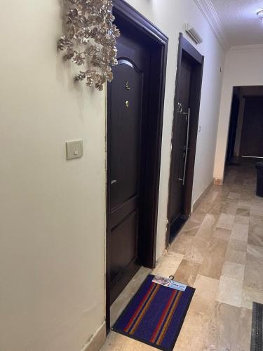a hallway with two brown doors and a rug at Furnished one bedroom apartment in Amman