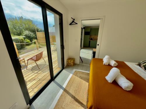 a bedroom with a bed and a view of a balcony at Maison des Chênes 64 - Spa Lodge in Boucau