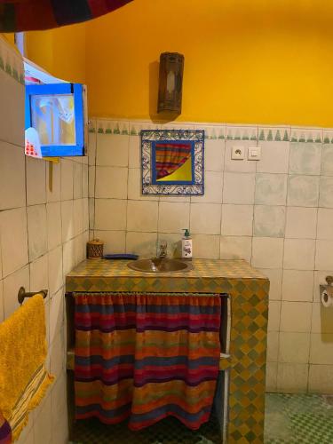 a bathroom with a sink and a colorful table at Riad Safi médina in Safi