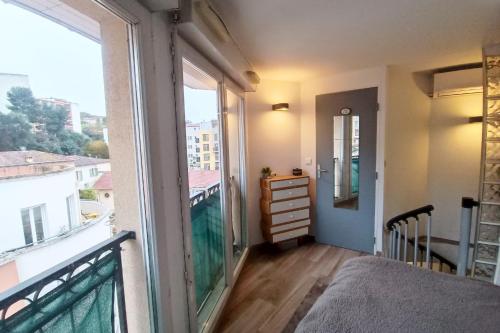 une chambre avec un balcon avec un lit et une fenêtre dans l'établissement Charming T2 with Wifi near city center, à Nice
