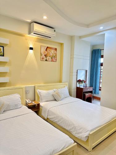 a hotel room with two beds and a air conditioner at Khách sạn Sinh Hiền in Liên Trì (4)