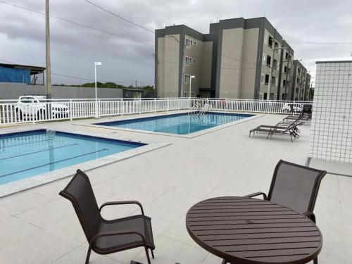 a patio with a table and chairs and a pool at AP a 3KM das PRAIAS, com SUÍTE in São Luís
