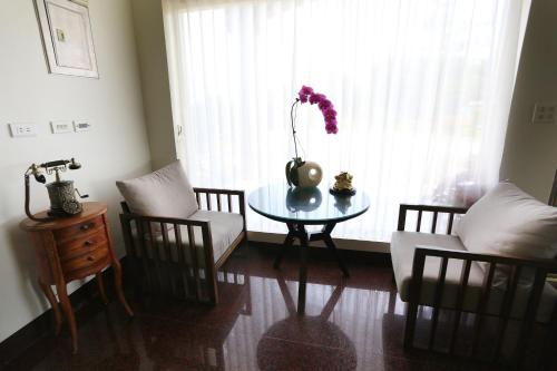 a living room with a table and chairs and a window at Campestral Garden in Jiaoxi
