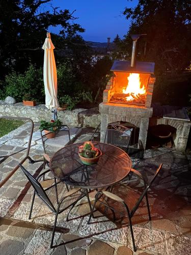 a patio with a table and a fire place at A due passi dai lupi in Civitella Alfedena