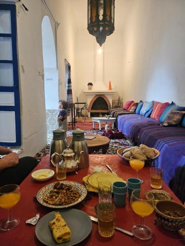 a living room with a table with plates of food at Riad Safi médina in Safi