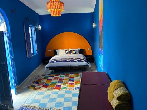 a bedroom with a bed with a blue wall at Riad Safi médina in Safi