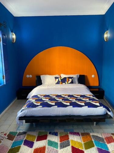 a bedroom with a large bed with a blue wall at Riad Safi médina in Safi