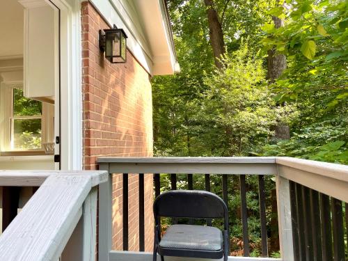 a black chair sitting on the porch of a house at Oak House in Silver Spring