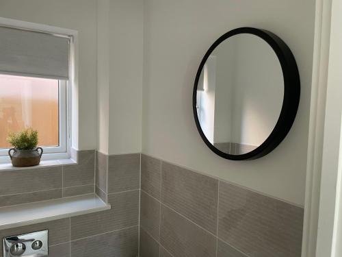 a bathroom with a mirror on the wall at Brand-New, 2 Private Bedrooms Available, Stunning Views, Stoke Hospital, Alton Towers, Keele University, Trentham Gardens, Free Parking & Wi-Fi in Silverdale