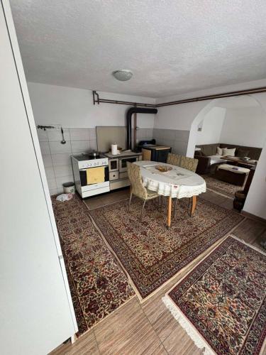 ein Wohnzimmer mit Tisch und Küche in der Unterkunft Secret garden in Visoko