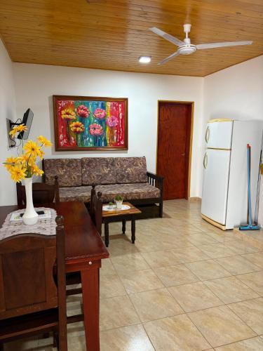 a living room with a couch and a refrigerator at HFB Aparts in Eldorado