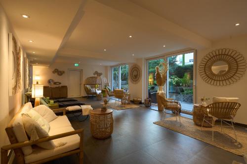 a living room with a couch and chairs at Kirchers Park & Wellnesshotel Kaiserstuhl Garni in Endingen