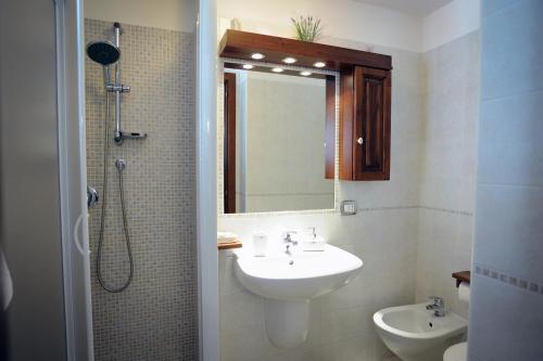 a bathroom with a sink and a shower with a mirror at Trullo Di Tagaro in Locorotondo