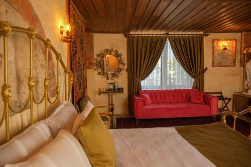 a bedroom with a bed and a red couch at Zeppelin Cappadocia in Uchisar