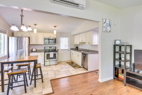 a kitchen with white cabinets and a table and chairs at 2 Mi to Warren Dunes Sawyer Apartment with Deck! in Sawyer